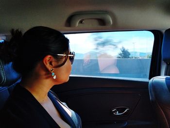 Woman looking away while sitting in car