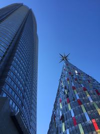 Low angle view of modern buildings against blue sky