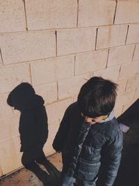 High angle view of boy standing against wall