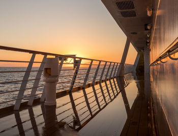 Pier over sea against sky during sunset