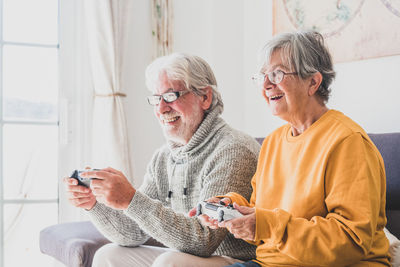 Man and woman playing video game at home