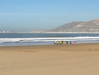 People at beach against sky