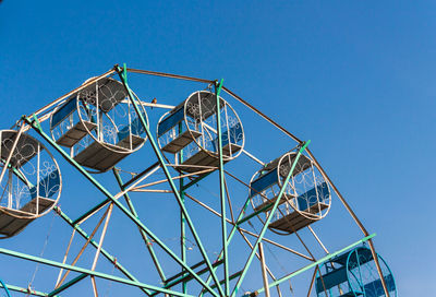 Low angle view of ferris wheel against clear blue sky