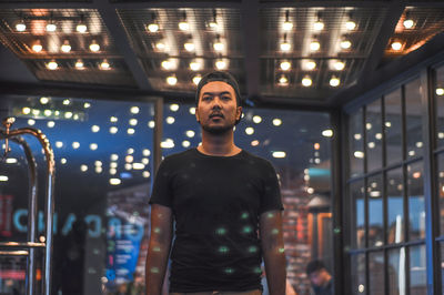 Low angle view of man standing in illuminated room