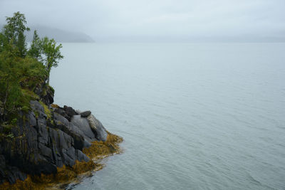 Scenic view of rocks in sea against sky