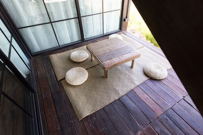 Low table and pillow on mat in wooden floor.