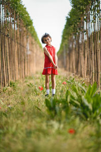 Full length portrait of girl standing on field