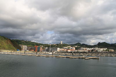 Buildings by sea against sky in city