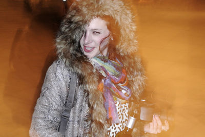 Portrait of young woman wearing fur coat