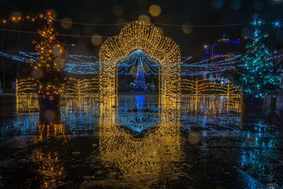 Digital composite image of illuminated city by lake at night