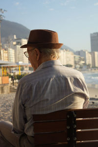 Rear view of man sitting on bench