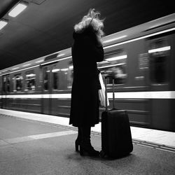 Blurred motion of woman standing on railroad station platform