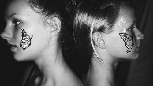 Two teenage girls with butterfly art on faces