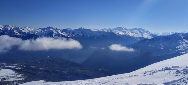 Scenic view of snowcapped mountains against clear blue sky