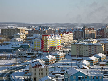 High angle view of townscape by sea against sky