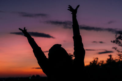 Silhouette person dancing against sky during sunset