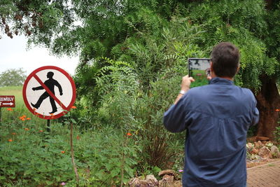 Rear view of man standing by road