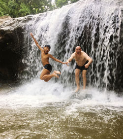 Boy and father jumped on waterfall