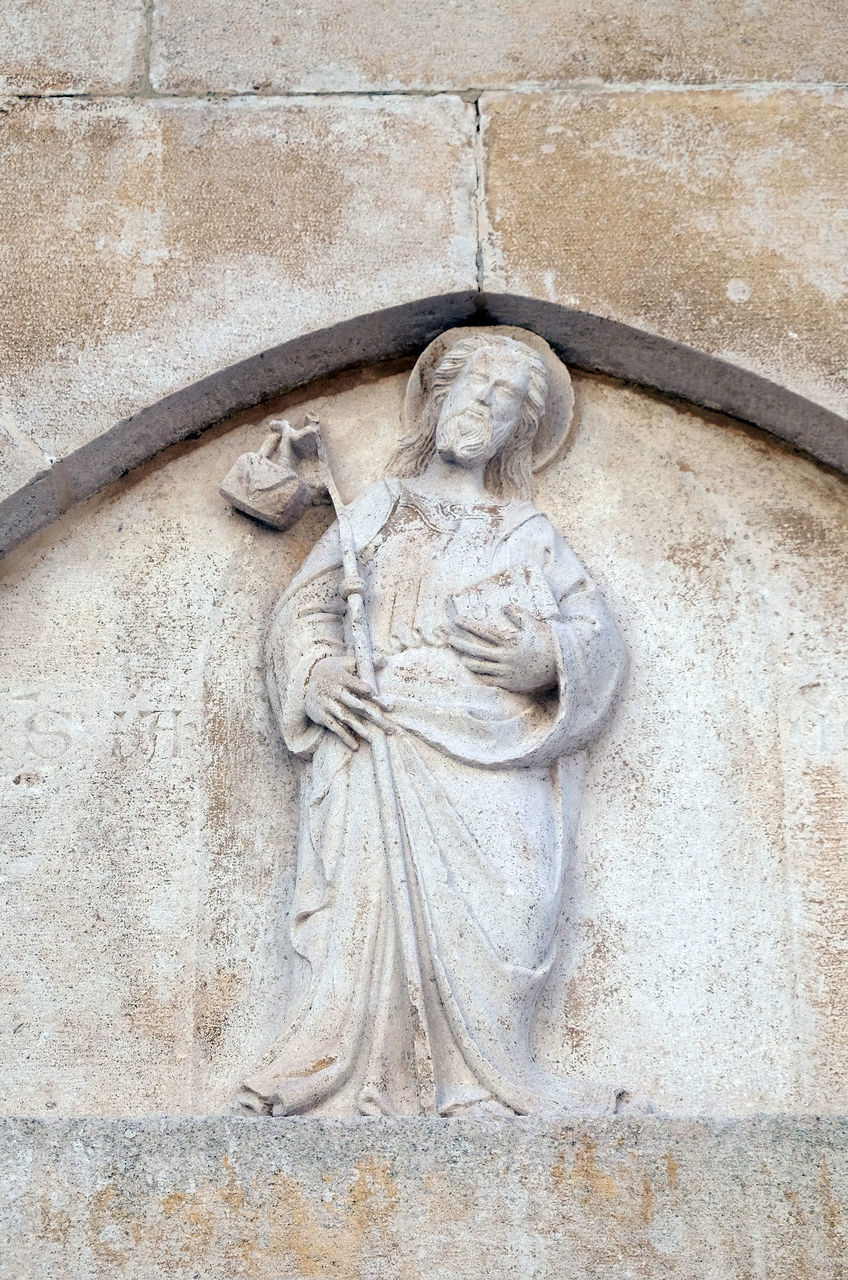 LOW ANGLE VIEW OF BUDDHA STATUE ON WALL