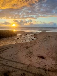 Scenic view of beach against sky during sunset