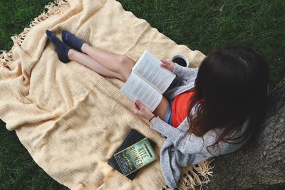 High angle view of woman lying on book