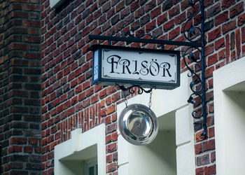 Low angle view of information sign on wall of building