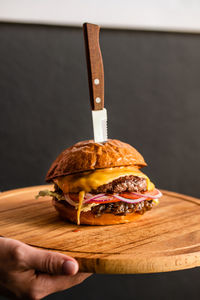 Appetizing cheeseburger with a knife on a board