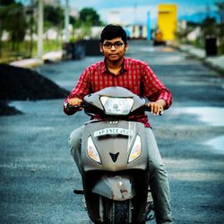 Young man riding motorcycle on street in city
