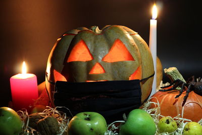 Close-up of illuminated candles against black background