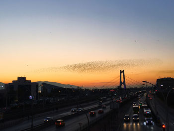 Traffic on road at sunset