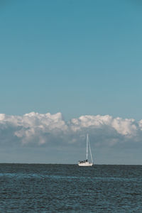 Sailboat sailing on sea against sky