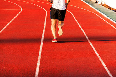 Low section of man running on track