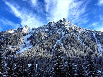 Low angle view of snowcapped mountain against blue sky