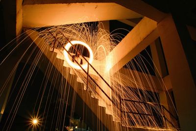 Low angle view of illuminated lighting equipment at night