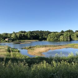 Scenic view of lake against clear blue sky