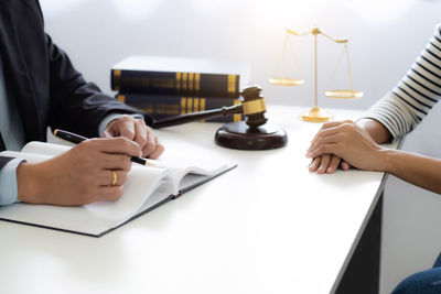 Midsection of man and woman on table