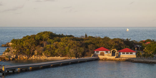 View of calm sea in front of built structure against sky