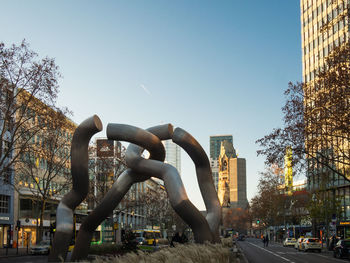 Street by buildings against clear sky