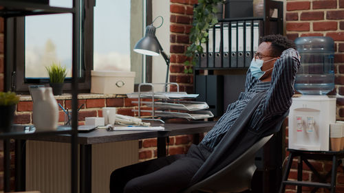 Side view of woman using mobile phone while sitting on table