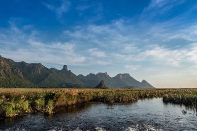 Scenic view of lake and mountains against blue sky