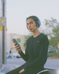 Young man using mobile phone while sitting on table