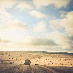 Hay bales on field against sky