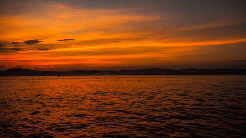 Scenic view of sea against dramatic sky during sunset