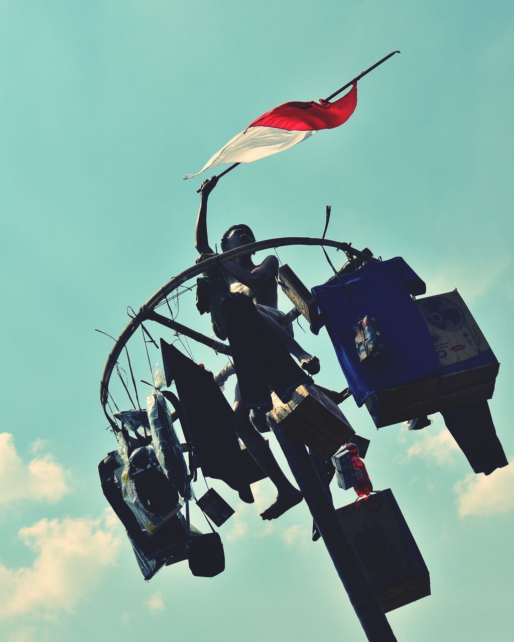 low angle view, sky, clear sky, blue, outdoors, day, hanging, metal, silhouette, arts culture and entertainment, no people, sunlight, machinery, technology, transportation, equipment, mode of transport, amusement park, old-fashioned, metallic