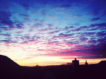 Silhouette of landscape against cloudy sky