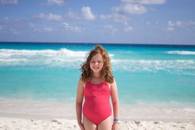 Portrait of smiling young woman standing at beach