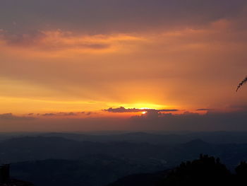 Scenic view of dramatic sky over silhouette landscape