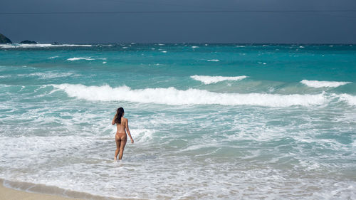 Full length of man standing on beach against clear sky