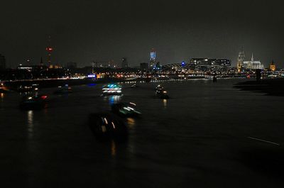 Illuminated cityscape against sky at night