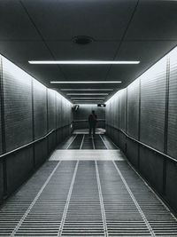 Rear view of man walking in subway tunnel